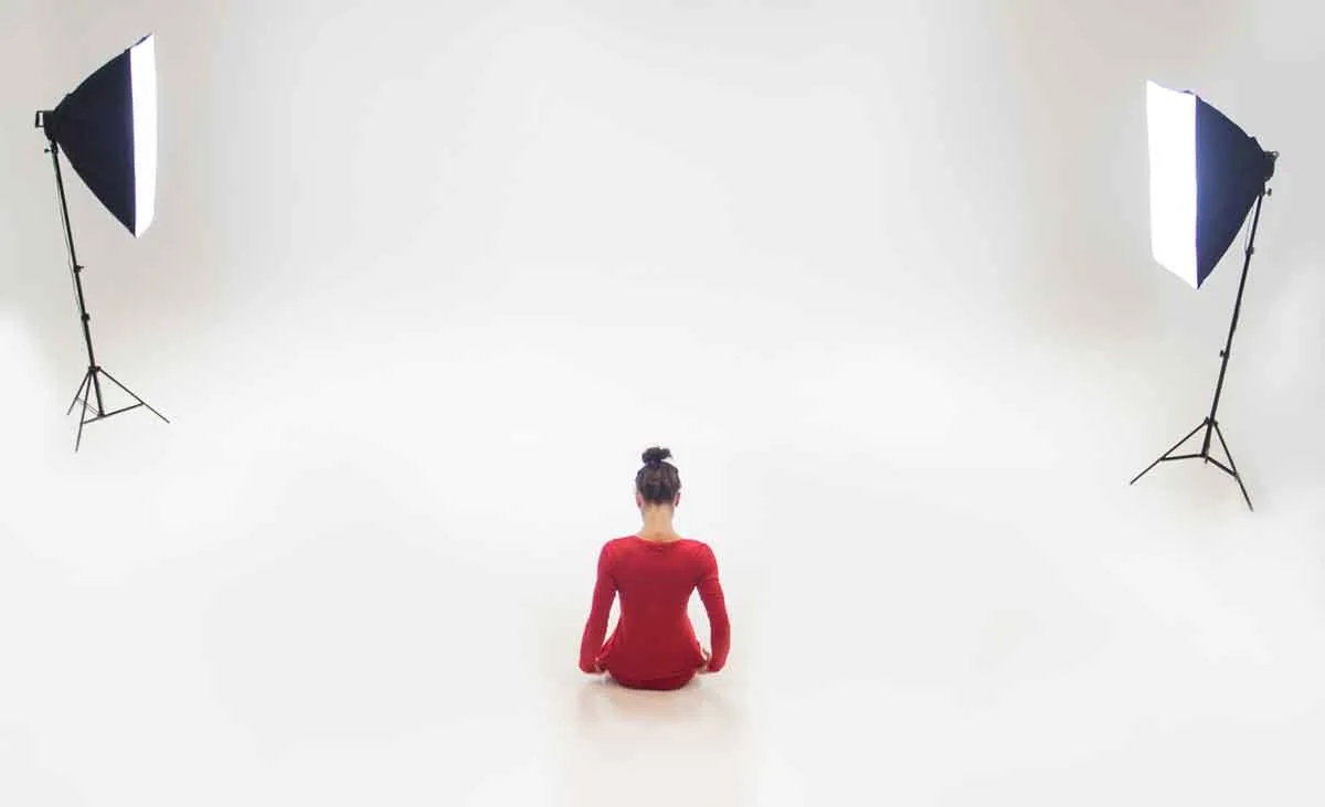 Model seated on the floor lit symmetrically by two softboxes