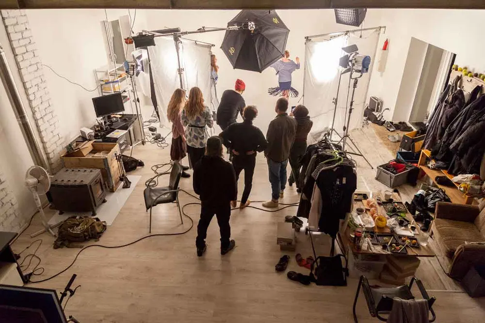 Overhead view of the full crew setting up a studio shoot with wardrobe rail and lighting